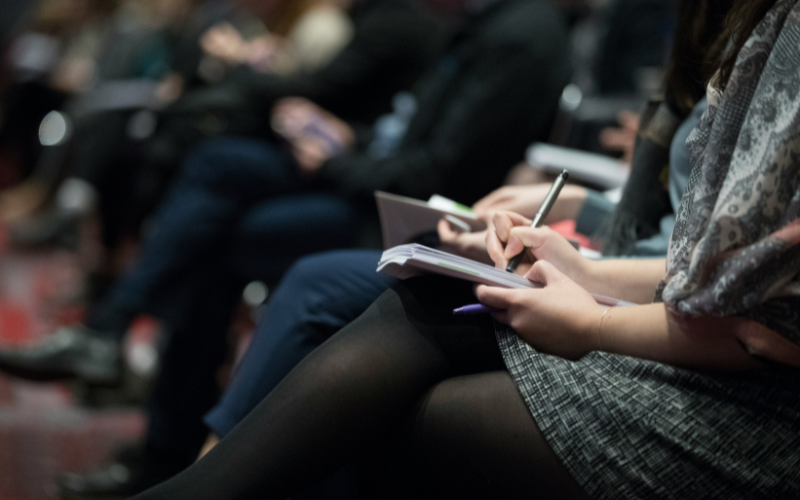 Group of reporters sitting and holding notepads